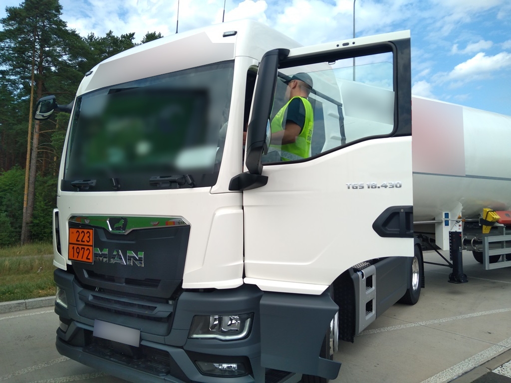 Inspektor ITD kontroluje ciężarówkę przewożąca towary niebezpieczne.